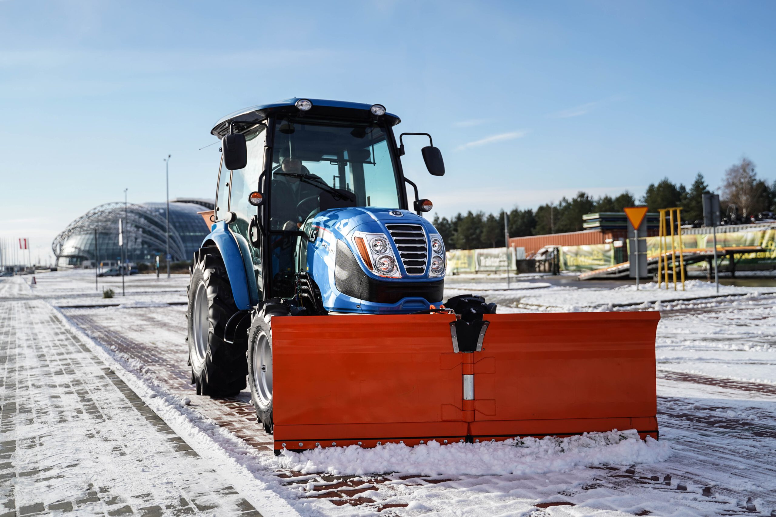 Traktor s radlicí na sníh s šípovým pluhem a posypovým vozem