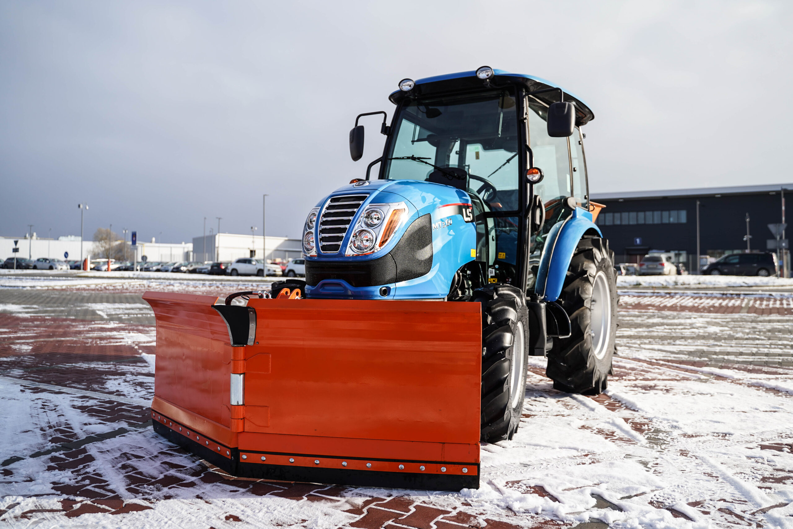 Traktor s radlicí na sníh s šípovým pluhem a posypovým vozem