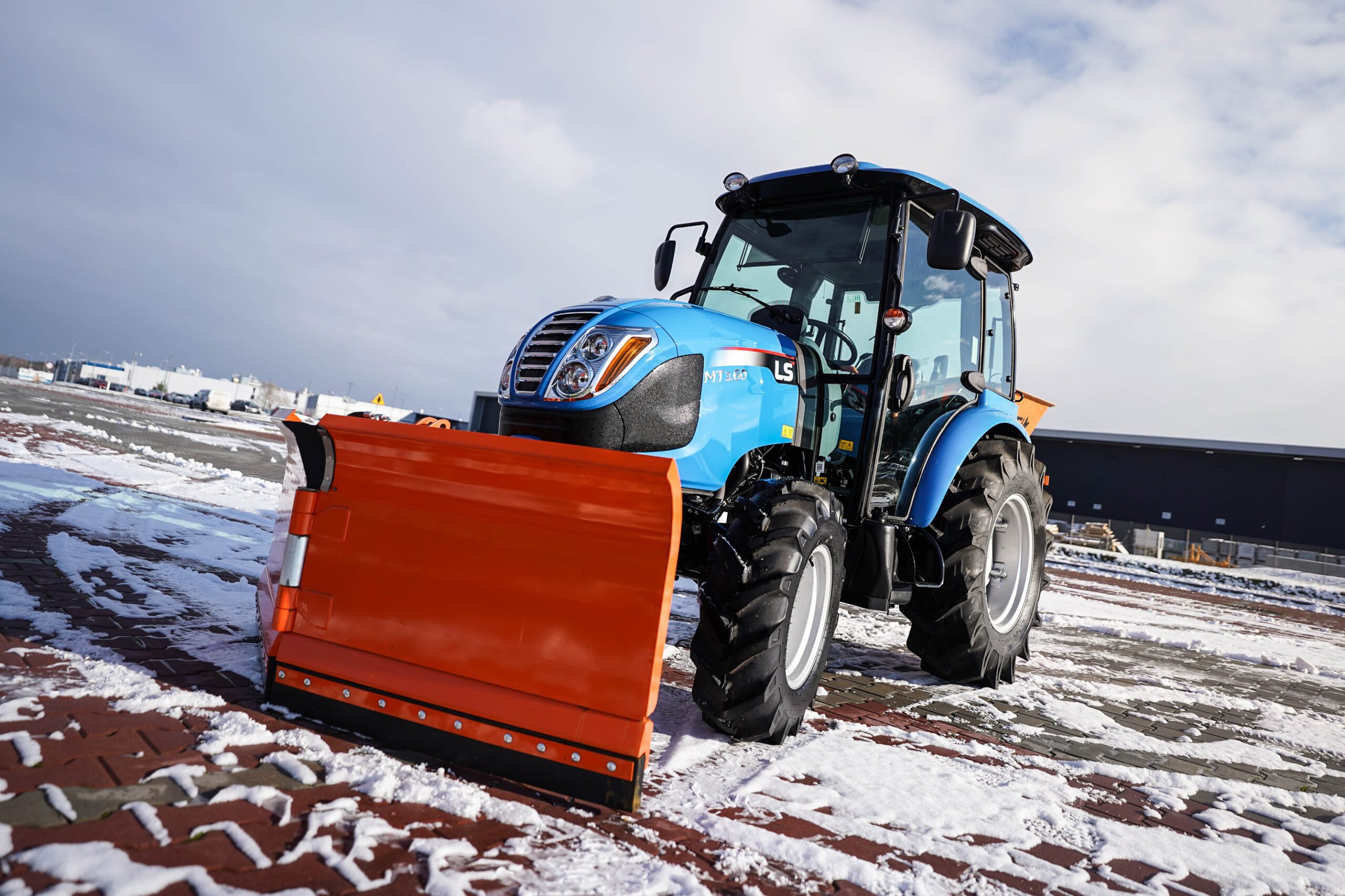 Traktor s radlicí na sníh s šípovým pluhem a posypovým vozem