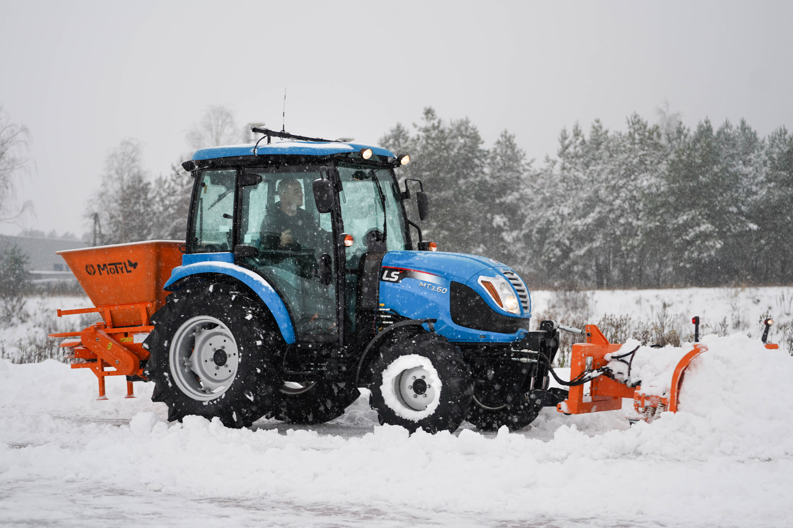 Traktor s radlicí na sníh s šípovým pluhem a posypovým vozem